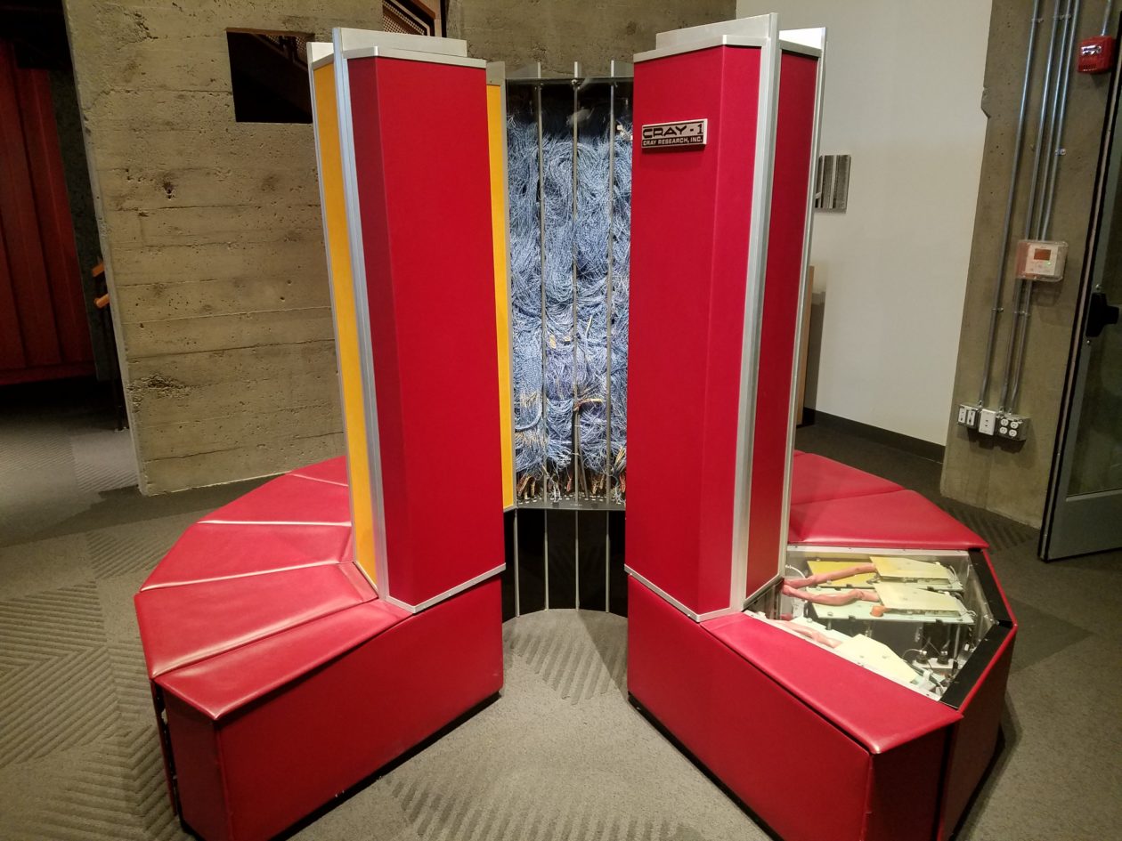 image of a Cray1 supercomputer in a red color in a room